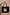 Thumbnail for Black canvas Life Is Tough Tote Bag featuring a leopard print patch and motivational slogan, held against a beige wall.