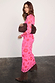 Pink and Red Morocco Mesh Dress with hand and eye motifs, styled with brown boots and a large brown clutch bag.