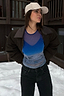 Ski Slopes Mesh Long Sleeve Top in blue with a ski slope print, layered under a dark jacket in a snowy setting.