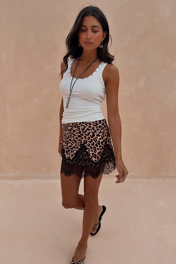 Leopard Lace Mini Maeva Skirt with black lace trim, worn with a white vest. Model is 5ft 7in and wears a UK size 10.