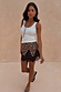 Leopard Lace Mini Maeva Skirt with black lace trim, worn with a white vest. Model is 5ft 7in and wears a UK size 10.