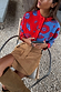 Blue and Red Holly Cardigan featuring iconic motifs, styled with a tan suede mini skirt and tall boots.