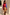 Thumbnail for Blue and Red Holly Cardigan featuring iconic motifs, tucked into a tan suede skirt and knee-high boots.