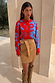 Blue and Red Holly Cardigan featuring iconic motifs, tucked into a tan suede skirt and knee-high boots.