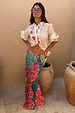 Pastel Morocco Dorris Skirt with multi-colour sun and snake motifs, shown on a model next to terracotta jars.