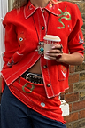 Red Mystical Cardigan with jacquard motifs and blanket stitch detailing, paired with blue jeans.