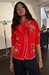 Red Mystical Knit Bandana with embroidery tied around the neck over a matching embroidered cardigan.