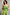 Thumbnail for Olive Lola Mid-axi Dress in green cotton with a ruched bodice and thin straps, styled with a patterned neck scarf.