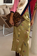 Olive Mystical Dorris midi skirt with celestial sun and moon motifs, paired with a statement leopard print clutch bag.