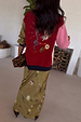 Olive Mystical Dorris Skirt in green with sun and moon motifs, styled with a colourful embroidered cardigan.