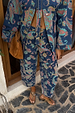 Denim Paisley Barrel Leg Jeans in blue with pink and teal patterns, styled with a matching shacket and brown suede bag.