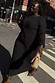 Black Plisse Perrie Dress with sheer balloon sleeves and a tie waist, worn by a model for inclusive sizing on a city walk.