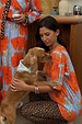Blue Poppy Print Jersey Pyjamas with orange poppies and leopard trim, worn by a model cuddling a dog.