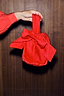 Red Velvet Bow Bag with a large bow detail and elasticated opening, held by a hand.