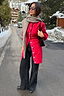 Red Ski Knit Long Cardigan with blue buttons and embroidered motifs, styled with wide-leg jeans in a snowy resort.