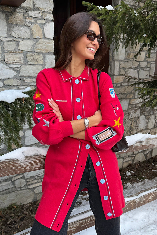 Red Ski Knit Long Cardigan featuring embroidered motifs and blue buttons, styled in a snowy setting.