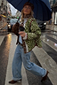 Pink Dallas Reversible Jacket in green deer print with quilted fabric and lace cuffs, styled on a rainy street.