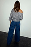 Gunmetal Sequin Tilly Top with an asymmetric silhouette and shimmering finish, shown from the back with denim jeans.