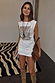 White Sequin Ruched Dress with a silver sequin panel and side ties, styled for a festival look.