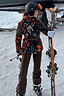 Thumbnail for Leopard Ski Trousers paired with a patterned ski jacket, shown on a model with skis in a snowy landscape.