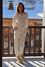 White Ski Waffle Pyjamas featuring a textured base and ski print, worn by a model on a snowy alpine balcony.