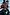 Thumbnail for Night Garden Ski Suit with leopard and poppy motifs, shown on a model in a ski lift holding ski poles.
