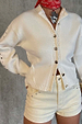 Ecru Studded Cardigan featuring silver studs and twist stitch detailing, worn with matching cream shorts.