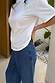 Blue denim barrel jeans featuring silver stud detailing along the pockets and side seams, styled with a white tee.