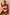 Thumbnail for Orange Sun High Waist Bikini Brief with iconic sun motifs and a fine line print on a model leaning against a wall.