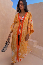 Yellow Sun Kimono in Soleil print with orange trim, tie front and wide sleeves, styled for a vacation with a beaded bag.