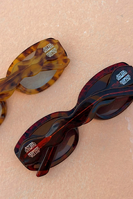 Red and amber tortoise acetate sunglasses featuring statement wiggle arms and NFD branded detailing.