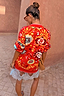 Tomato Tapestry Martha Cardigan in red with celestial sun motifs, shown from the back in a relaxed fit.