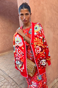 Red Tomato Tapestry Martha Cardigan with celestial sun motifs and pink blanket stitch edging on a model.