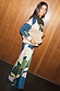 Teal Mara Abstract Dorris Skirt with a pink and green print, styled with a matching cardigan and beige suede clutch.