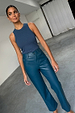 Teal straight leg vegan leather trousers and a navy ribbed tank top worn by a model.