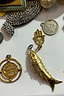 Thumbnail for Gold-tone jewellery charms featuring an articulated fish and Hamsa hand, reflecting NFD X Caetana inspiration.