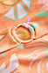Orange Dreamer Scoop Swimsuit detail featuring the gold ring buckle and iconic palm and sun print on orange fabric.