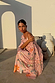 Pink Sun Anais Dress featuring iconic soleil motifs and gold flecks with a sheer off-shoulder top and satin-esque skirt.
