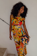 Rio A-Symmetric Top and matching skirt in a colourful fruit print, styled as a co-ord with a patterned clutch.