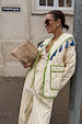 model is wearing the quilted striped jacket in a pastel yellow with the matching trouser and a suede bag 