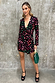 Black Animal Verity Top with a pink and green leopard print, bell sleeves and tie front on a model.