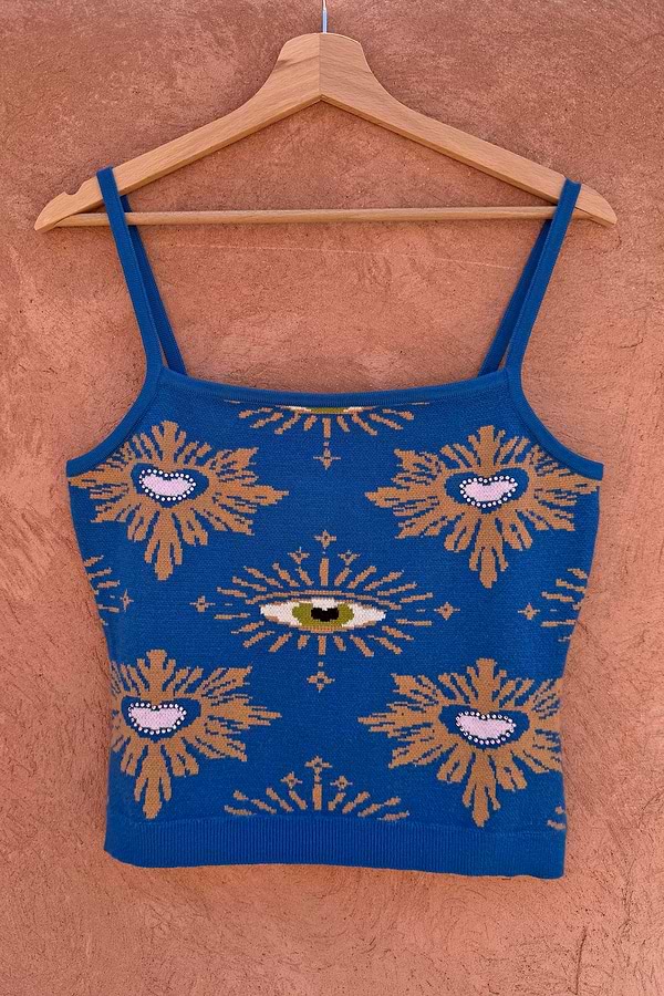 Blue Eye Knitted Cami Top with heart and eye motifs and a square neckline, hanging on a wooden hanger.