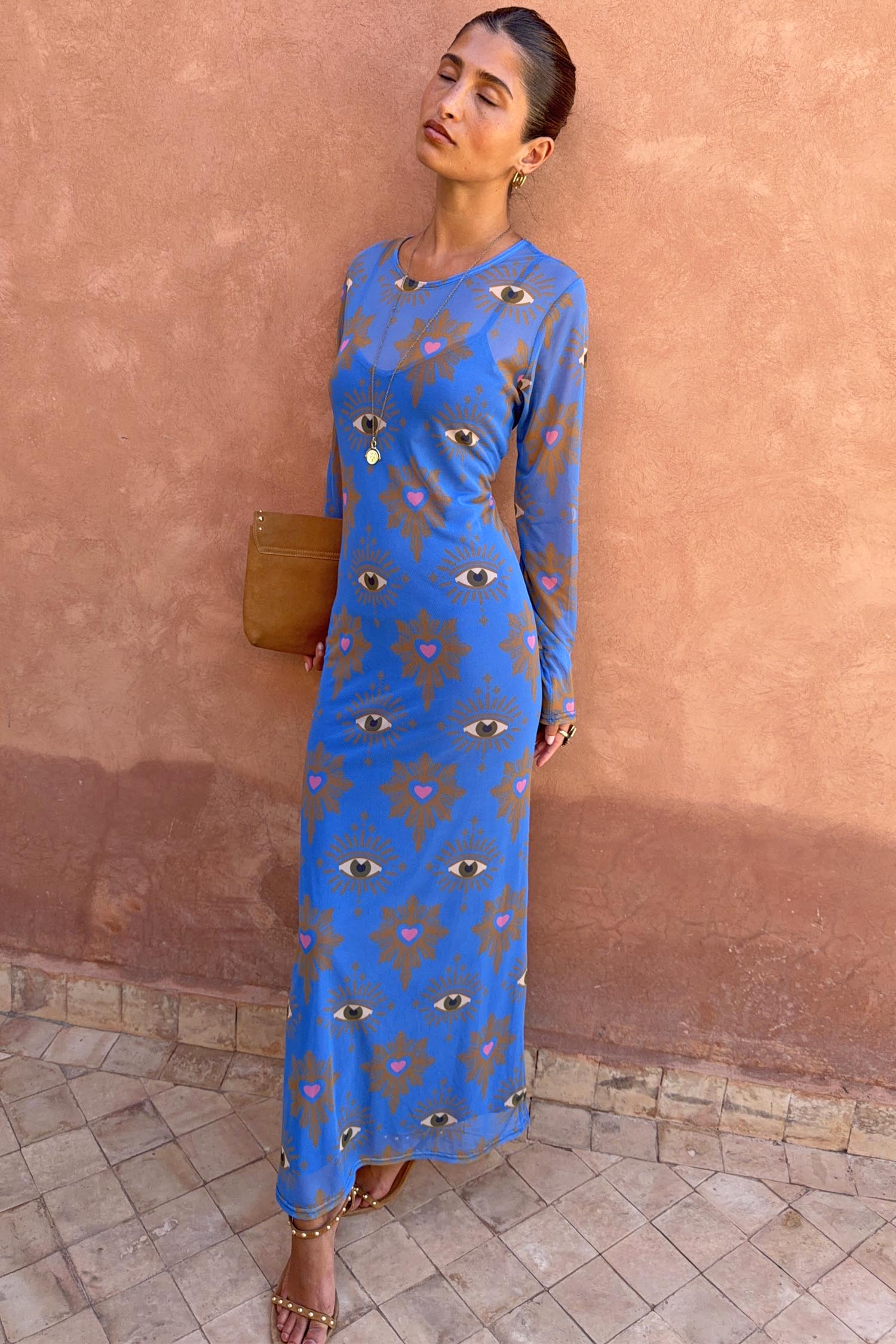 Blue Eye Mesh Dress with eye and heart motifs, long sleeves and a fitted maxi silhouette, styled on a model.
