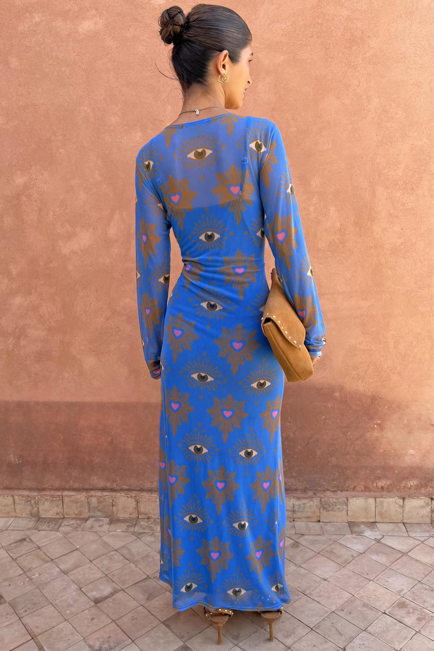 Blue Eye Mesh Maxi Dress with heart and eye motifs and long sleeves, shown from the back on a model.