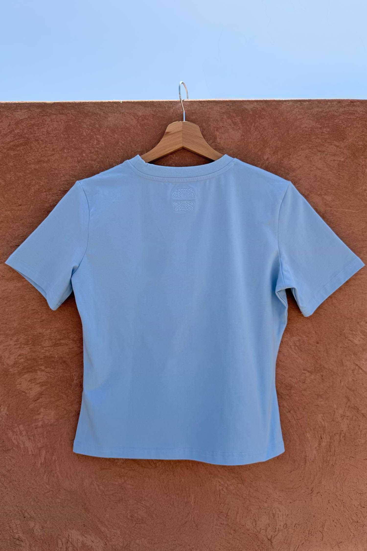 Blue Cadillac Baby T-Shirt back in stretch cotton with tonal embroidery, hanging on a wooden hanger.