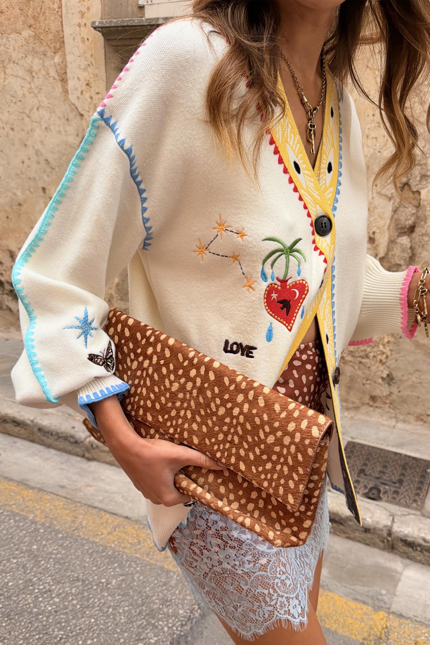 Cream Celestial Martha Cardigan with celestial motifs and colourful stitching, styled with an animal print clutch.