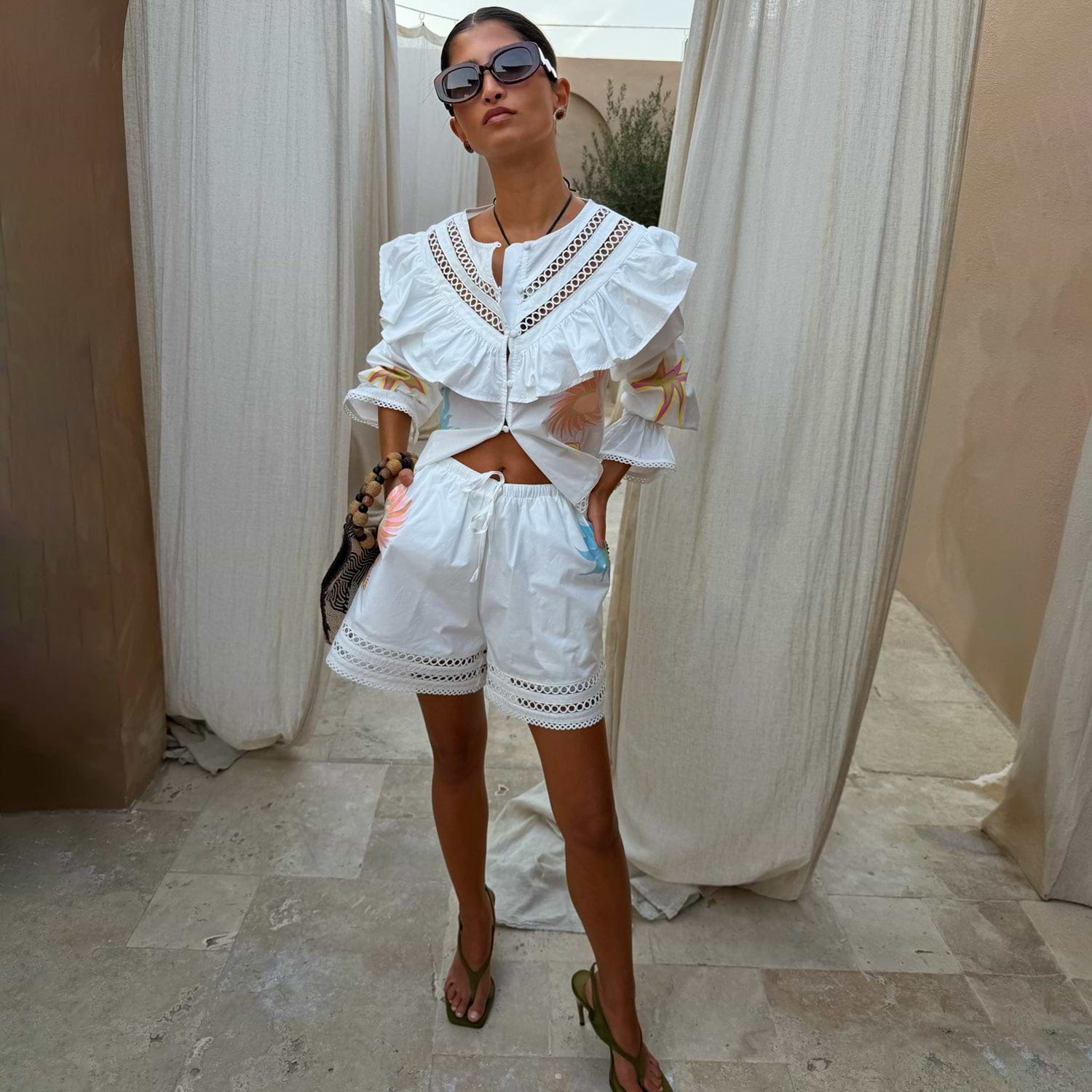 Dreamer Willa Top in white cotton with iconic sun motifs, ruffle cutout neckline and flared cuffs, styled as a co-ord.