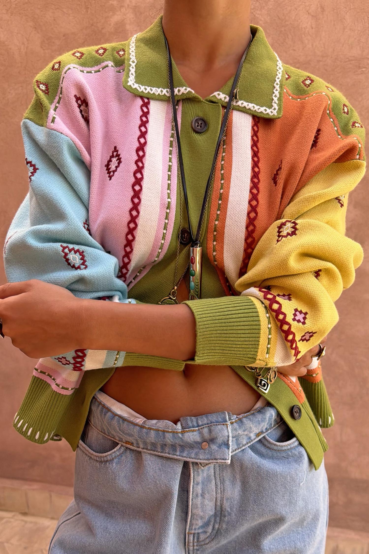 Geometric Palm Cardigan in green with colourful jacquard motifs and blanket stitch detailing.