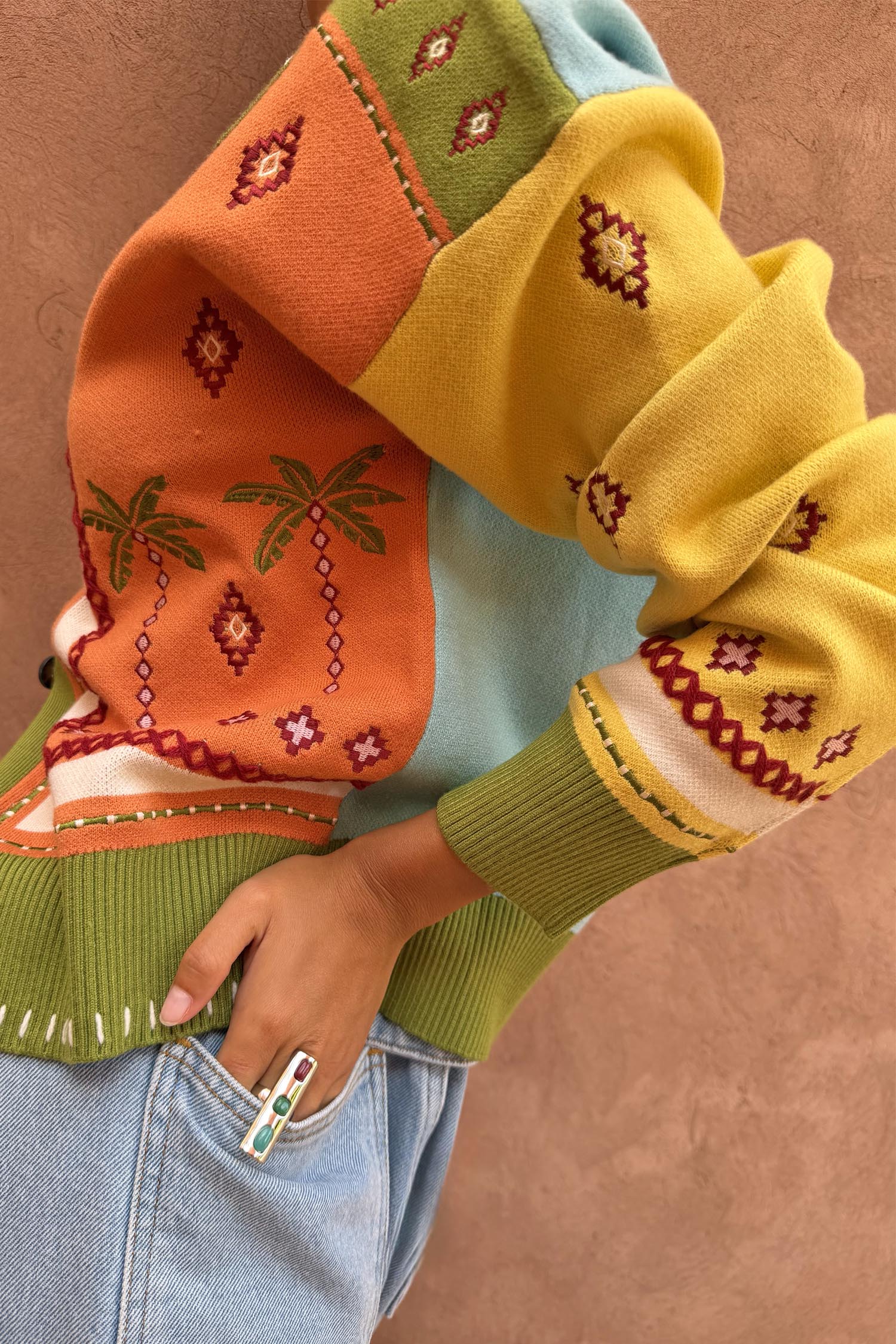 Geometric Palm Cardigan in a multi-colour knit featuring palm motifs, jacquard patterns and blanket stitch details.