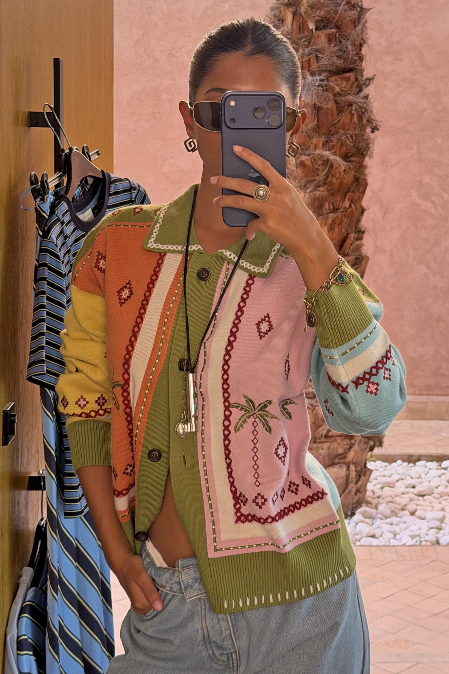 Geometric Palm Cardigan in green with multi-coloured jacquard motifs and blanket stitch detailing in a mirror selfie.